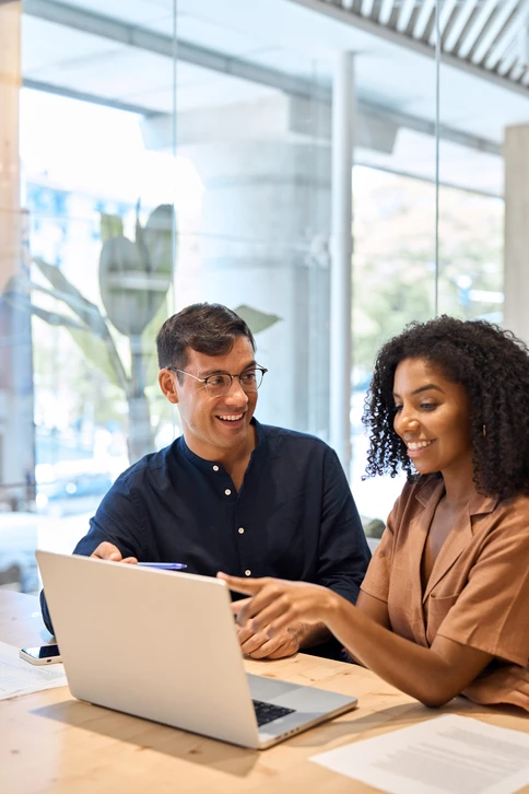 Divers collaborateurs professionnels parlent de technologie financière ou de données marketing à l'aide d'un ordinateur portable au bureau