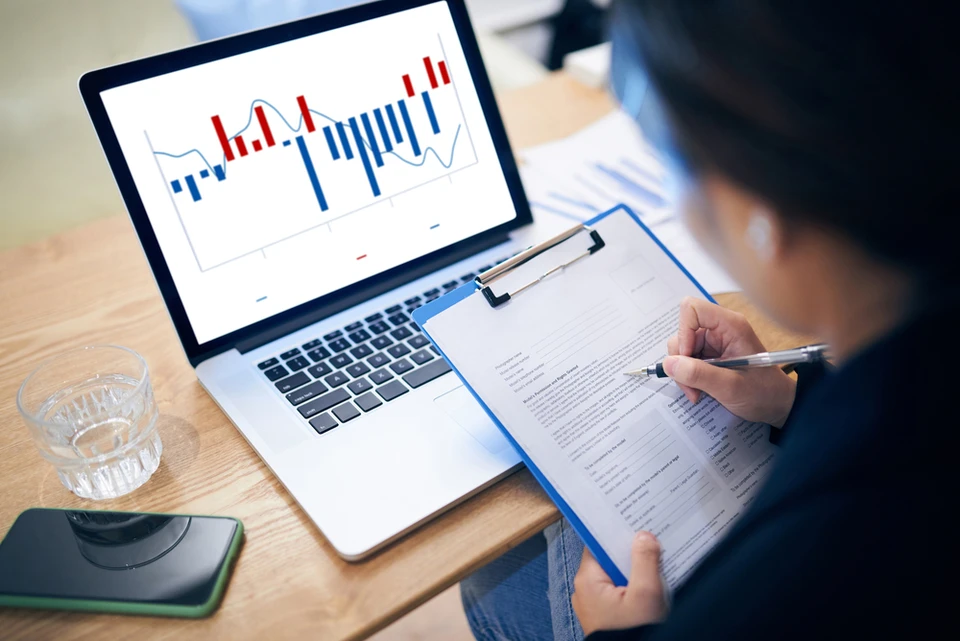 Deux professionnels en costume analysent des données financières dans un bureau moderne